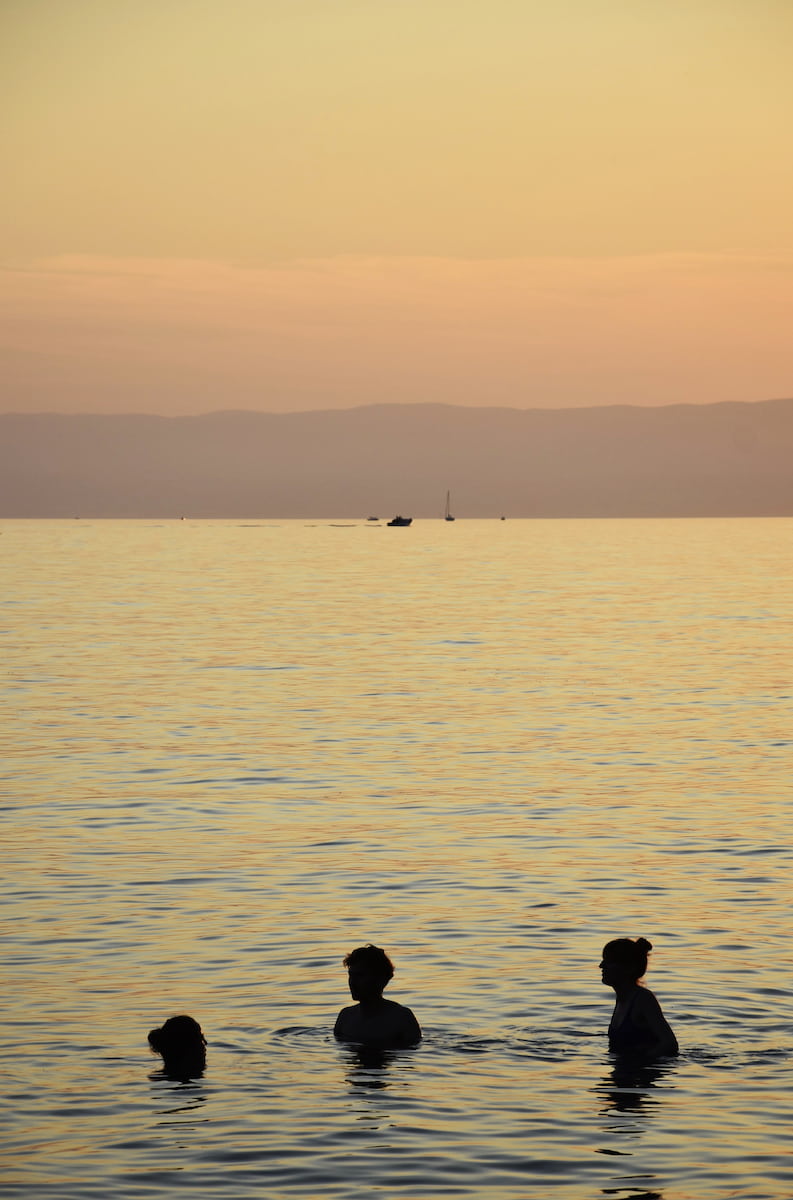 Derniers baigneurs dans le coucher de soleil sur le lac de Genève Vevey