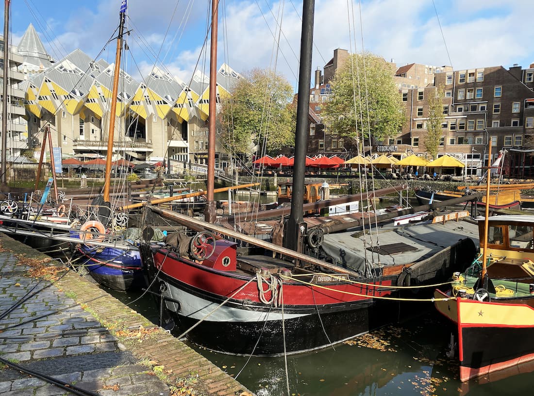 Au premier plan, les vieux bateaux au second plan les maisons cubes de Rotterdam