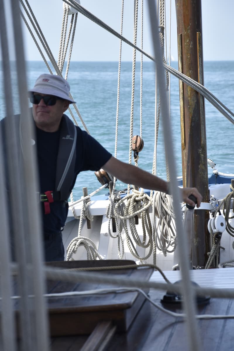 Le capitaine à la barre de la bisquine La Granvillaise pendant la navigation