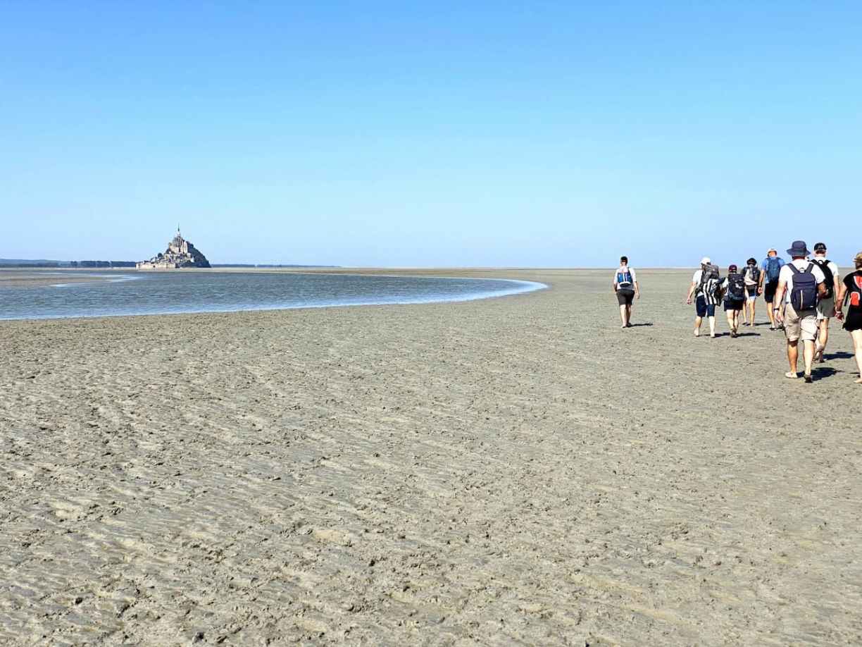 Groupe de randonneurs marchant dans la baie du Mont-Saint-Michel