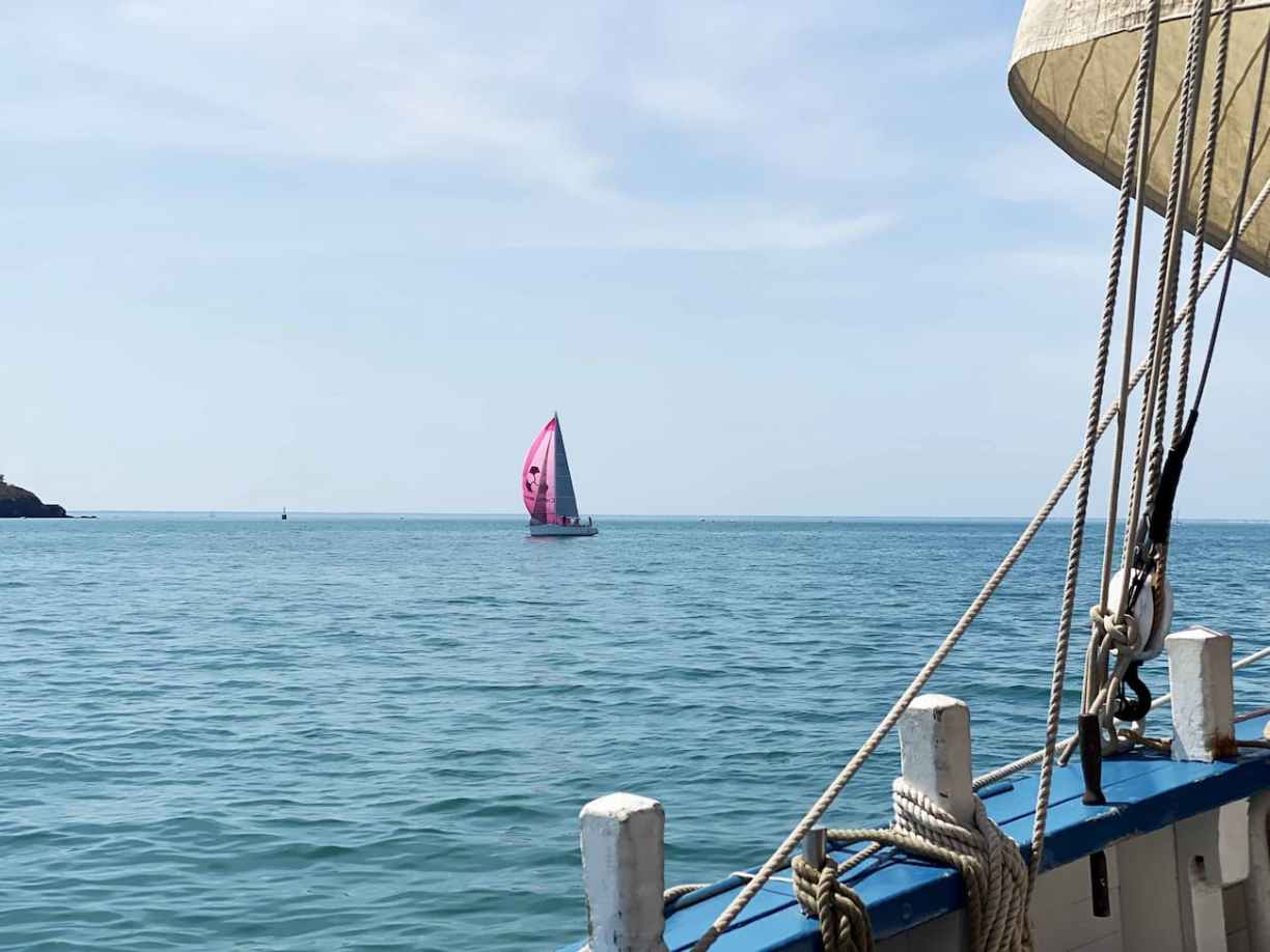 Voilier sous spi devant la pointe du Roc de Granville