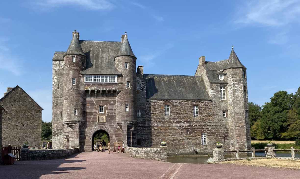 Façade du château médiéval de Trécesson entouré de douves