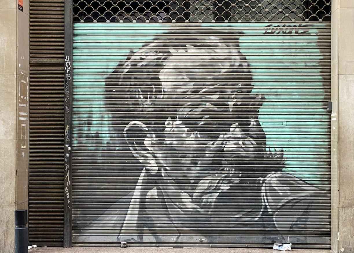 Street art peint sur le rideau métallique d’un commerce dans le quartier d’El Raval à Barcelone