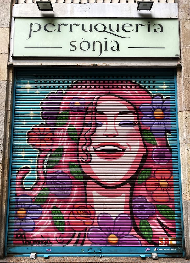 Street art sur le rideau métallique d’un magasin de perruques dans l’Eixample à Barcelone