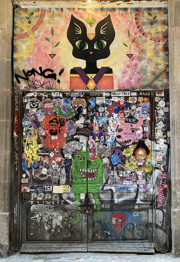 Œuvre de street art sur une porte dans une ruelle d’El Born à Barcelone